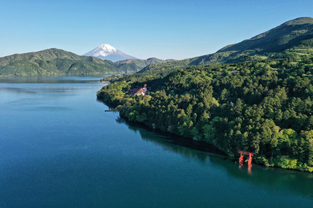Summer view across Lake Ashi toward Mount Fuji with Hakone Shrine torii visible by the water