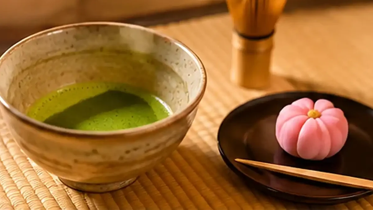 Bowl of matcha with a bamboo tea whisk and wagashi during a Japanese tea ceremony